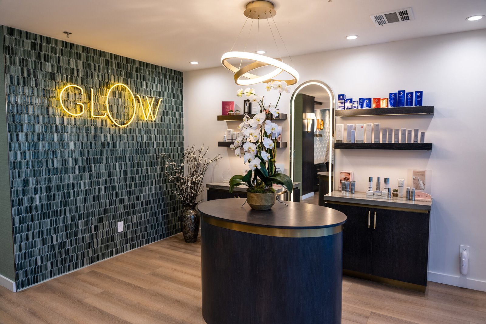 Glow Aesthetic Center reception with illuminated GLOW sign